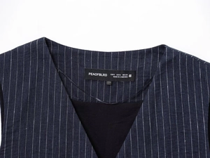 Close-up of a navy blue striped linen-blend vest collar with detailed size label