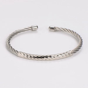 Detail of silver twisted cable bangle with diamond-cut pattern on polished stainless steel
