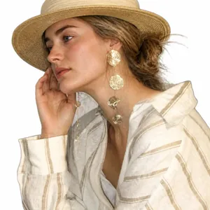 Golden multi-layer wavy disc tassel earrings on female model with summer resort vibe