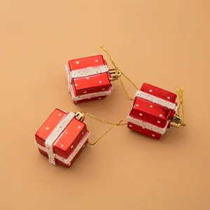 Three red Christmas gift box ornaments with white glitter ribbon and golden hanging loops