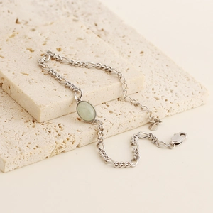 Detail view of green aventurine gemstone set on s925 silver chain over stone texture