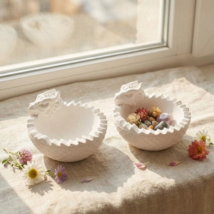 Detailed view of white dragon relief storage bowls with diamond pattern on linen
