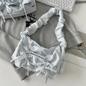 Detailed view of blue and white striped tote bag featuring bow and ruffled shoulder strap