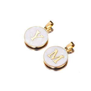 Detailed macro view of retro stainless steel pendants with M and Y golden letter charms