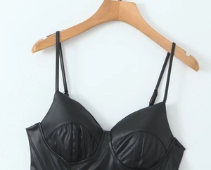 Detalle de camisola de cuero sintético negro con copas estilo corsé en percha