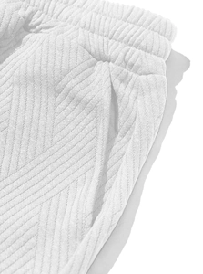Detail of white herringbone texture fabric on loose fit men's shorts with elastic waist