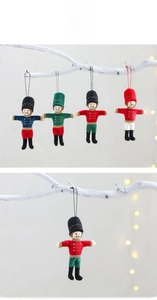 Detail of plush nutcracker soldier ornaments in various colors hanging on a festive branch