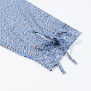 Detail of blue and white striped shirt cuff featuring an elegant decorative bow tie