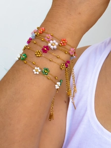 Close-up of bohemian colorful beaded flower bracelets set with gold stainless steel chain