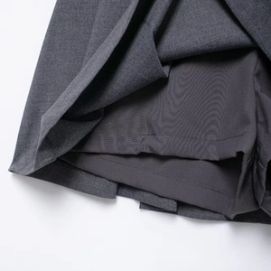 Dark gray pleated mini skirt featuring a built-in safety short design and smooth fabric