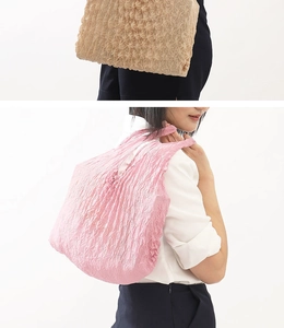 Detail of expandable pleated tote bags in beige and pink colors shown on models