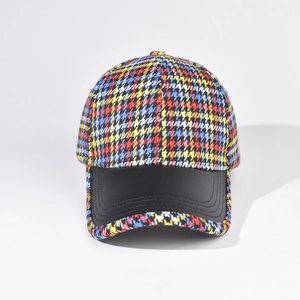 Detail of multi-color plaid fabric crown and black PU leather brim with double stitching