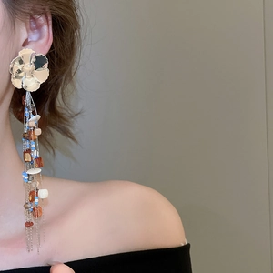 Model wearing bohemian floral tassel earrings with colorful resin beads and gold chains