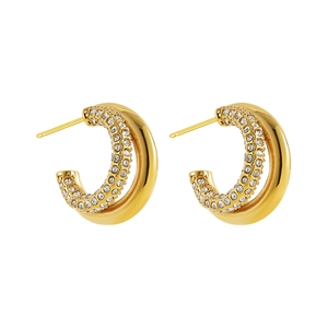 Macro shot of gold-plated C-shaped hoop earrings with sparkling white cubic zirconia inlay