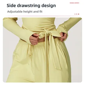 Close-up of adjustable side drawstrings on yellow long sleeve yoga fitness top