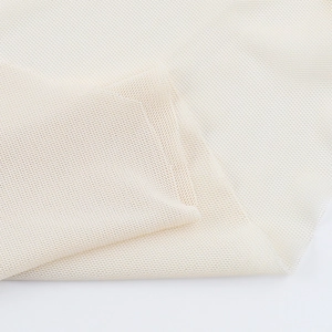 Close-up van ademende crème mesh-stof voor een sexy haltertopje voor dames