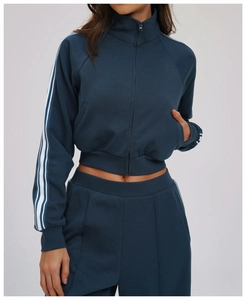 Detail of navy blue windproof tracksuit showing side stripes and front zipper closure