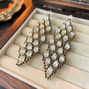 Elegant hollow zircon tassel drop earrings with gold finish in a vintage jewelry box
