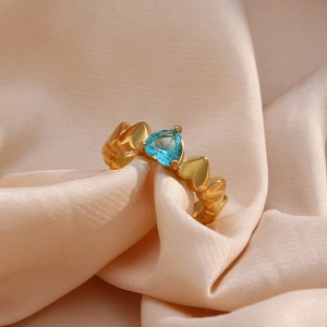 Close-up of a gold 18K plated heart ring featuring a brilliant blue zircon gemstone