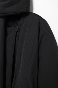 Detailaufnahme der schwarzen Oversize-Steppjacke mit Schalkragen und matter Nylontextur