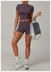 Vista completa del set yoga viola con pantaloncini a vita alta e top corto sportivo