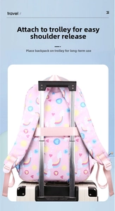 Pink school backpack with rainbow prints featuring a back strap for suitcase attachment