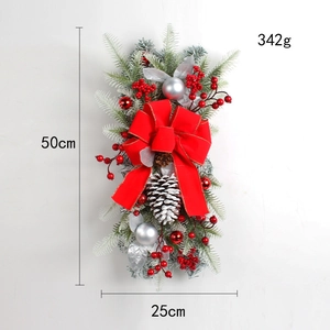 Close-up of Christmas swag with red berries, pine cones, and a large red bow detail