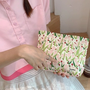 Handheld canvas tulip cosmetic bag with floral print and side label for travel storage
