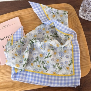 Detail of floral cotton linen headscarf with daisy patterns on a rustic wooden tray