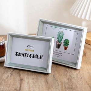 Minimalist light blue picture frames with white matting on a cozy wooden table setup