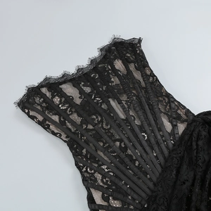 Détail de robe courte en dentelle noire avec baleines en satin et bordure en dentelle