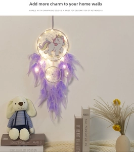 Detail of unicorn dream catcher with purple feathers and warm white LED string lights
