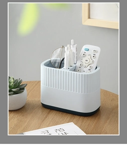 Close-up of a two-tone white and blue multi-compartment desk organizer with stationery