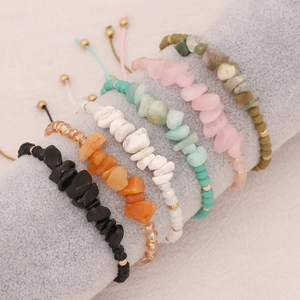 Handmade natural stone beaded bracelets in multiple colors with gold accents on display