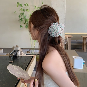 Pinza per capelli a fiori in rete indossata da una modella in un giardino zen calmo
