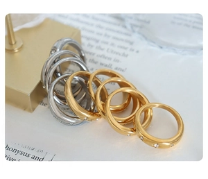 Detail of gold and silver stackable rings with star engravings on an open book page