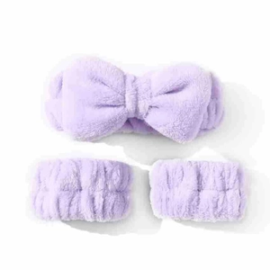 Close-up of purple coral fleece spa headband and wristbands set with large bow detail