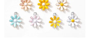 Macro shot of colorful daisy flower pendants in alloy and enamel for jewelry making