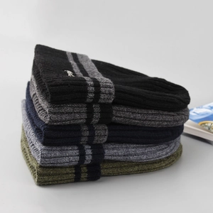 Detail of layered ribbed knit beanies in various colors with metallic accents