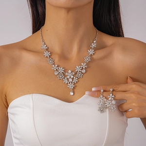 Close-up of floral snowflake pendant necklace and earrings set with sparkling crystals