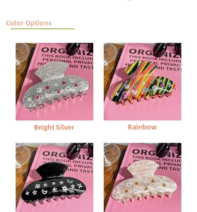 Detail of star and moon hair claws in silver glitter, rainbow, black and pearl white finishes