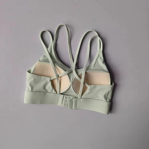 Detail view of criss-cross back straps and adjustable hook closure on green sports bra