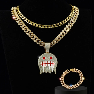 Close-up of gold iced-out ghost face pendant and matching cuban link chain jewelry set