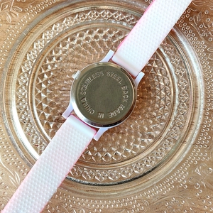 Macro shot of the stainless steel back cover and pink silicone strap of the girl's watch