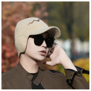 Detailed knit texture of beige winter hat with earflaps worn by male outdoors