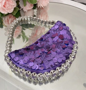 Close-up of luxury purple sequin crescent bag with sparkling rhinestone borders