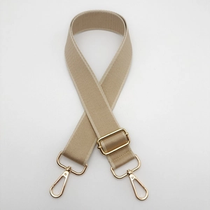 Detailed view of beige adjustable shoulder strap with premium gold metal hardware buckles