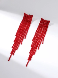 Macro detail of long red rhinestone tassel earrings with a shimmering tiered chain effect