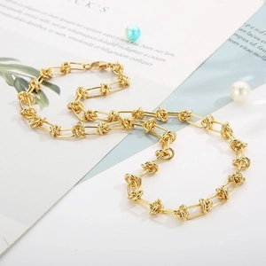 Close-up of golden paperclip knot link necklace with pearl and ins-style decor
