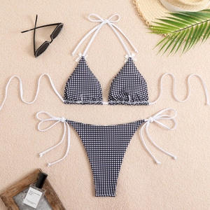 Flat lay of vintage black and white checkered bikini with halter top and side-tie bottoms